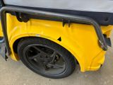 a close up of a yellow golf cart parked on the street