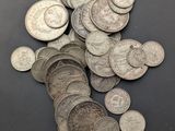 some silver coins are scattered on a black surface