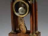 a small wooden clock with a bell on top of it