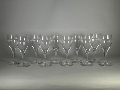six verres à vin vides sont alignés sur une surface blanche