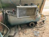 an old air conditioner sitting on the ground next to a pile of tools