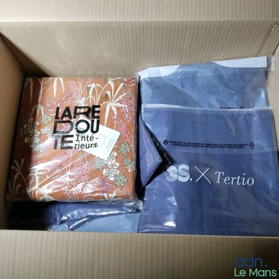 a box of clothing and a bag of clothing inside of it