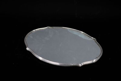 an oval mirror with a silver frame on a black background