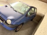 une petite voiture bleue garée dans un parking couvert