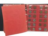 an open red folder with coins inside of it on a white background
