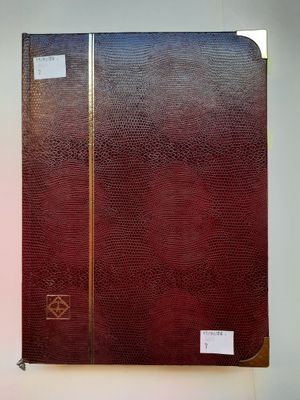 un livre rouge aux tranches dorées posé sur une table