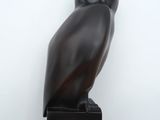 une statue de chouette noire posée sur un bloc de bois