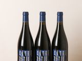trois bouteilles de vin posées sur une table en bois