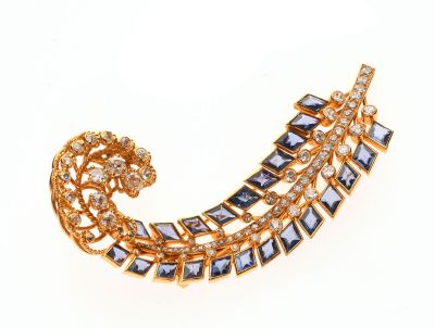 une image représentant une broche en or ornée de pierres bleues et blanches