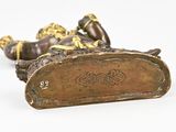 two bronze figurines of a man and a woman laying on their backs