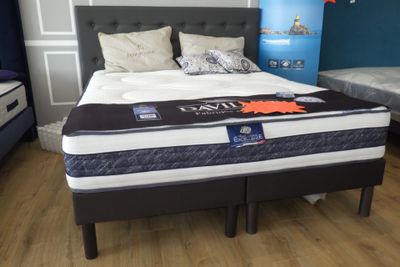 un lit sur lequel est posé un matelas dans une pièce