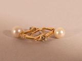 a close up of a pearl and gold ring on a white surface