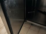 someone is opening the door of a stainless steel refrigerator in a kitchen