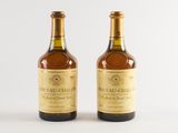 two bottles of wine sitting next to each other on a white surface