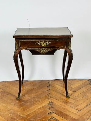 une photo représentant une petite table en bois avec un plateau en marbre, posée sur un parquet