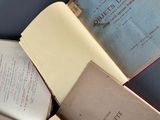 several open books sitting on top of each other on top of a table