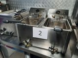 two deep fryers sitting on a table in a kitchen