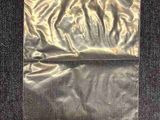 un sac en papier d'argent posé sur un tapis noir