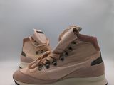 La chaussure est rose et comporte un lacet sur le côté.