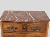 a marble top chest of drawers with brass handles
