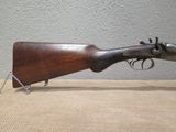 an old rifle is sitting on a table next to a wall