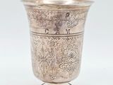 une tasse en argent antique avec un motif floral sur le bord