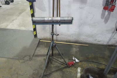un tuyau métallique posé sur un trépied dans un garage