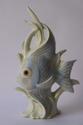 une figurine de poisson blanche et bleue posée sur une table blanche