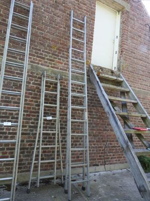 ladders leaning up against a brick building next to a window