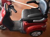 a red scooter with a black seat and a black seat