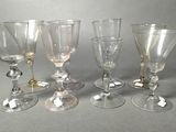 four wine glasses sitting next to each other on top of a table