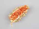 orange rose hair clip with gold leaves on a gray background
