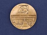 a gold medal with a picture of a man on it