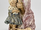 figurine d'une femme tenant un bébé dans ses bras