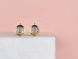 a pair of gold and white druzy stud earrings on a marble block