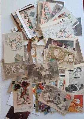 de nombreuses cartes postales anciennes posées sur une table recouverte d'une nappe rouge