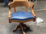 une chaise en bois avec une assise en cuir bleu dans une pièce