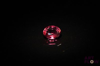 gros plan d'un diamant rose sur une surface noire
