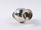 a close up of a silver object on a white surface