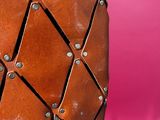 a close up of a brown leather bag with rivets on it