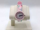 a small pink watch sitting on a white stand
