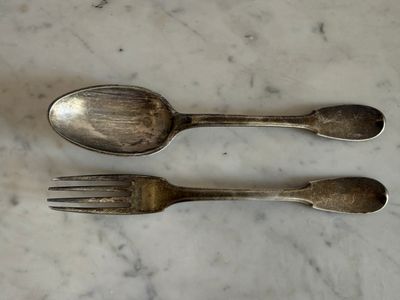 deux cuillères et une fourchette posées sur une table en marbre