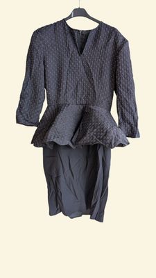 grey dress on a hanger in front of a white background