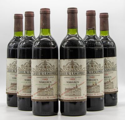 six bouteilles de vin sont alignées sur une surface blanche