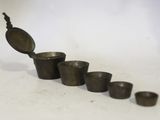 cinq tasses et une cuillère posées les unes à côté des autres sur une table