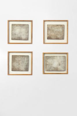 four framed photographs of a man sitting on a bench in front of a white wall
