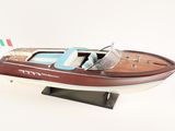 wooden model of a speed boat on a stand on a white surface