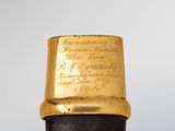 a close up of a black and gold cane with writing on it