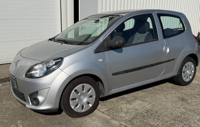 a small silver car parked in front of a garage