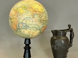deux vases placés à côté d'un globe terrestre posé sur un socle